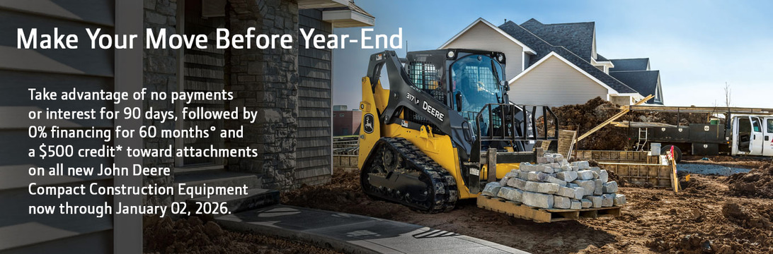John Deere skid steer moves concrete blocks at a residential construction site.